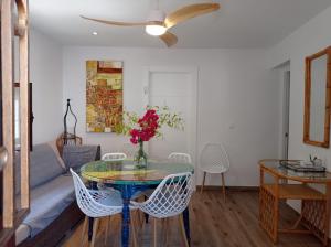 una sala de estar con una mesa con un jarrón de flores en Villa Garrido en El Pozo de los Frailes