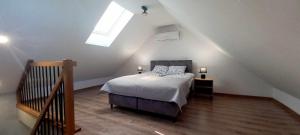 a bedroom with a bed and a skylight at Apartamenty w sam las by KLIF Ustka - apartament dwupoziomy z klimatyzacją i widokiem na las in Ustka