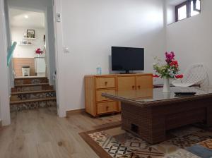 a living room with a tv on a wooden cabinet at Villa Garrido in El Pozo de los Frailes