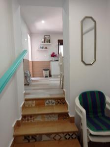 a hallway with stairs with a chair and a mirror at Villa Garrido in El Pozo de los Frailes