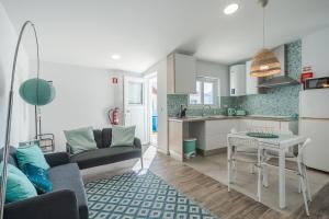 eine Küche und ein Wohnzimmer mit einem Sofa und einem Tisch in der Unterkunft Casa das Andorinhas in Sintra