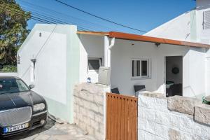 un'auto parcheggiata di fronte a una casa bianca di Casa das Andorinhas a Sintra