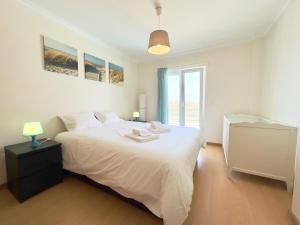 a bedroom with a large white bed and a window at Baleal Happy Family Apartment in Ferrel +31 photos