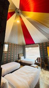 DisahにあるLulua luxury campのサーカス天井の客室で、ベッド3台が備わります。