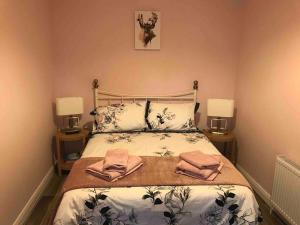 Cosy Nook Cottage Kesh في Kesh: غرفة نوم عليها سرير وفوط