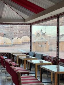 DisahにあるLulua luxury campのテーブルと椅子、大きな窓のあるレストラン