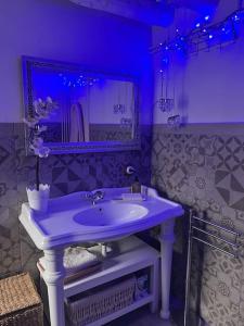 ein lila Badezimmer mit einem Waschbecken und einem Spiegel in der Unterkunft El 15 de Betren in Betrén
