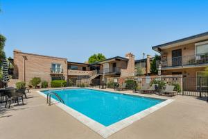 a swimming pool with tables and chairs next to a building at Casa Feliz in Scottsdale