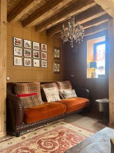 a leather couch in a living room with a chandelier at El 15 de Betren in Betrén