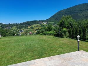 een grasveld met uitzicht op een berg bij Villa Usivak for green quiet holiday near Sarajevo in Sarajevo