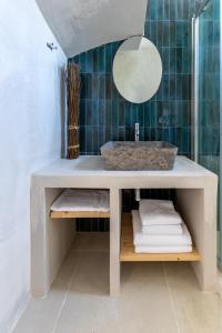 W łazience znajduje się umywalka i lustro. w obiekcie portokoufovillas w mieście Porto Koufo