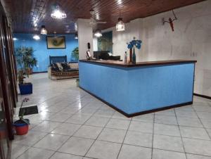 a lobby with a blue counter and a couch at Búzios – Geribá – Suítes - Aluguel Econômico in Búzios