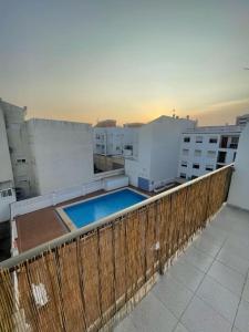 - un balcon avec une piscine au-dessus d'un bâtiment dans l'établissement Precioso duplex y espacioso en la playa de Gandía, à Playa de Gandia