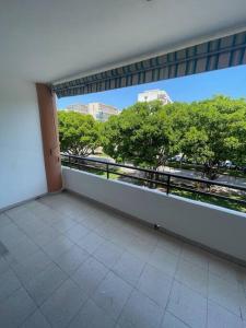 d'un balcon avec vue sur les arbres et les bâtiments. dans l'établissement Precioso duplex y espacioso en la playa de Gandía, à Playa de Gandia