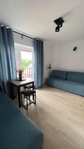 salon z niebieską kanapą i stołem w obiekcie Kraken-pokoje gościnne w mieście Krynica Morska