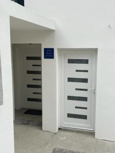 two garage doors in a white building with a sign at Apartment Klementina FREE PARKING in Zagreb