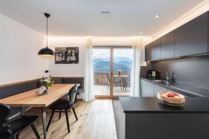 een keuken met een tafel en een eetkamer bij HAUSERHOF CHALET in Villanders - moderne Wohnungen mit 2 Badezimmer und 2 Schlafzimmer in Villandro
