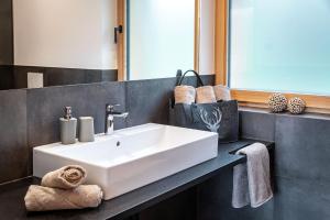 een badkamer met een witte wastafel en een spiegel bij HAUSERHOF CHALET in Villanders - moderne Wohnungen mit 2 Badezimmer und 2 Schlafzimmer in Villandro