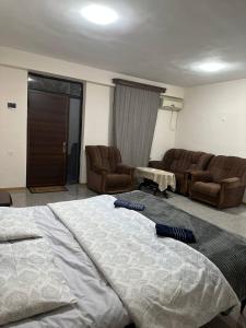 um quarto com uma cama grande e um sofá em Merys food corner & Hotel em Yeghegnadzor