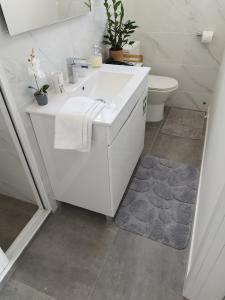 bagno bianco con lavandino e servizi igienici di Alexia Room a Funchal