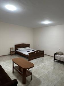um quarto com uma cama, uma mesa e um sofá em Merys food corner & Hotel em Yeghegnadzor