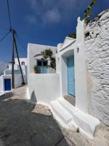 Biały budynek z niebieskimi drzwiami w obiekcie Dream House Little Villa - Amorgos w mieście Amorgós
