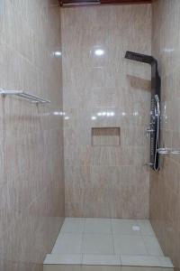een douche met een glazen deur in de badkamer bij Nzuri Nest Apartments Zuba in Kigali
