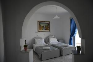 2 camas en una habitación con un arco en MIMIS APARTMENTS en Kefalos
