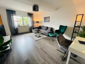 ein Wohnzimmer mit einem Sofa und Stühlen in der Unterkunft gemütlich*Nespresso*Netflix*Arbeitsplatz*Parkplatz in Duisburg