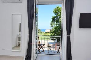 Habitación con una puerta corredera de cristal que da a un balcón. en Addore Re Mare en Santa Maria di Castellabate