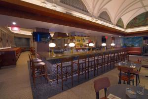 a restaurant with a bar with chairs and tables at Hotel Edison Times Square in New York