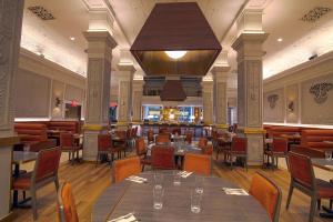 ニューヨークにあるホテル エジソン タイムズ スクエアのテーブルと椅子、大きなシャンデリアのあるレストラン