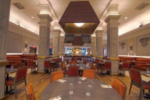 een restaurant met tafels en stoelen en een grote kroonluchter bij Hotel Edison Times Square in New York