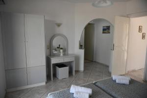 baño con 2 camas, lavabo y espejo en MIMIS APARTMENTS en Kefalos