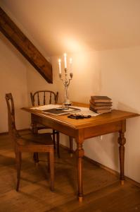 a wooden table with two candles and two chairs at Transylvania Guesthouses in Cincşor