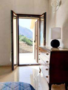 una camera da letto con cassettiera e ampia finestra di Vitam House a Castelbuono