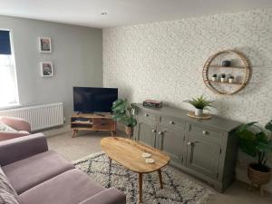 a living room with a couch and a tv at 10A Ruston Chambers Free parking, Luxury 2 bedroom city center apartment in St Ives