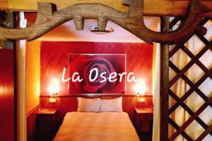 - une chambre avec un lit et un panneau indiquant l'opéra dans l'établissement zentralclub La Osera visionando la naturaleza, à Santiago del Hermo