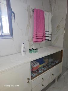 a bathroom with a vanity with a pink towel at Xhumba Guesthouse in Dhuvjan +30 photos