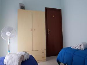 1 dormitorio con 2 camas, ventilador y armario en La Maison di Arya, en Riposto