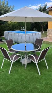 a table and chairs under an umbrella next to a pool at Cuencaloft Casa Rural Cañada Molina in Arcas