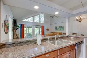 a kitchen with a sink and a living room at Fire Pit and Pool Access Margaritaville Home! in Osage Beach