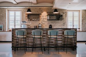 a bar with four stools in front of a brick wall at Garenne in Livron-sur-Drôme