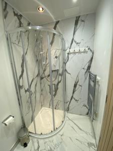 un bagno con box doccia e pareti in marmo. di 51 Innes Street Apartment a Inverness