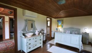 a bathroom with a white dresser and a mirror at Casa da Ramada, Turismo Espaço rural. in Ponte de Lima