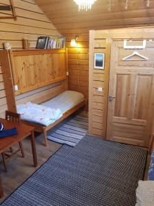 uma pequena cabana com uma cama e uma porta em Kolmården Apartments & Cottages em Stavsjo