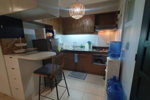 a kitchen with a counter and a table and chairs at Tropical Escape at Cedar Crest in Manila