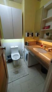 a bathroom with a toilet and a sink at Tropical Escape at Cedar Crest in Manila