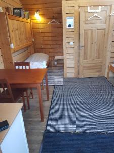 Pokój ze stołem, łóżkiem i drzwiami w obiekcie Kolmården Apartments & Cottages w mieście Stavsjo