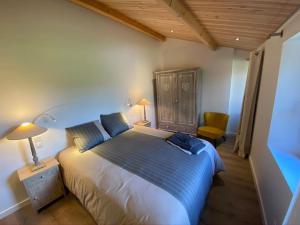 - une chambre dotée d'un grand lit blanc avec des draps bleus dans l'établissement Gite de charme au coeur des vignes, à Maisdon-sur-Sèvre